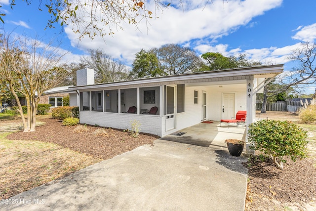 404 Mercer St, Oak Island, NC 28465 - ranch-style home with driveway, a sunroom, brick siding, a carport, and a chimney
