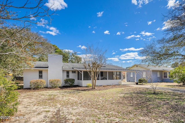 404 Mercer St, Oak Island, NC 28465 - view of front of property with a sunroom, a chimney, and roof with shingles