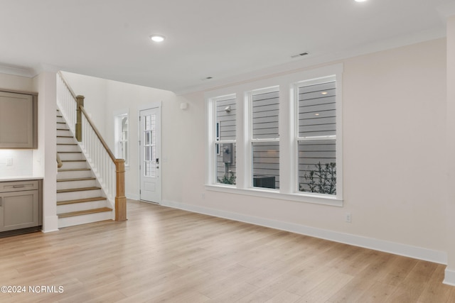 entryway featuring ornamental molding and light hardwood / wood-style floors