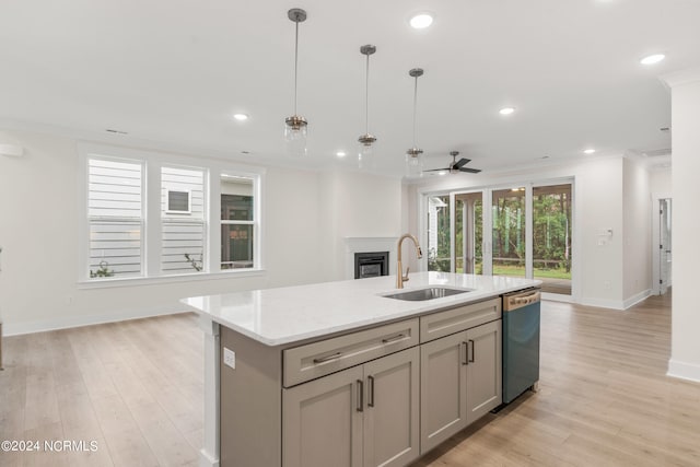 kitchen with an island with sink, decorative light fixtures, dishwasher, and sink