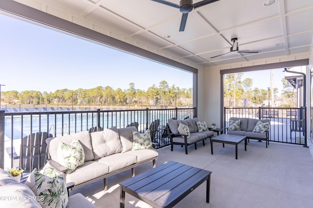 sunroom featuring ceiling fan and a water view