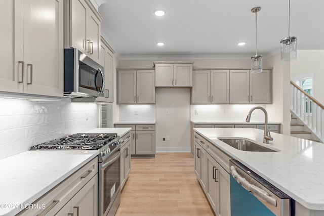 kitchen featuring sink, gray cabinets, pendant lighting, stainless steel appliances, and light stone countertops