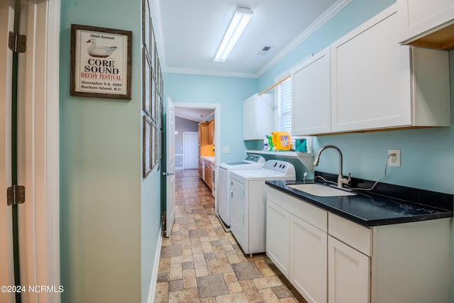 clothes washing area featuring ornamental molding, sink, cabinets, and independent washer and dryer