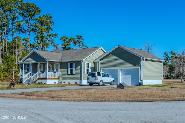 ranch-style house with a porch, a garage, and a front lawn