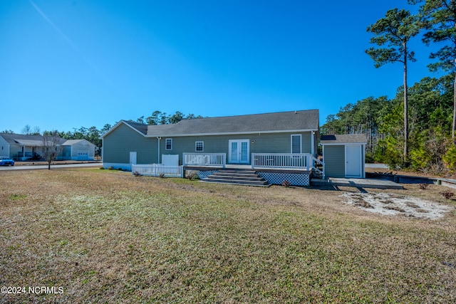 view of front facade with a front yard, a deck, and a storage unit