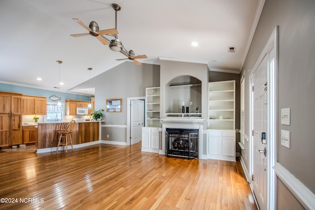 unfurnished living room with ceiling fan, a multi sided fireplace, light wood-type flooring, vaulted ceiling, and ornamental molding