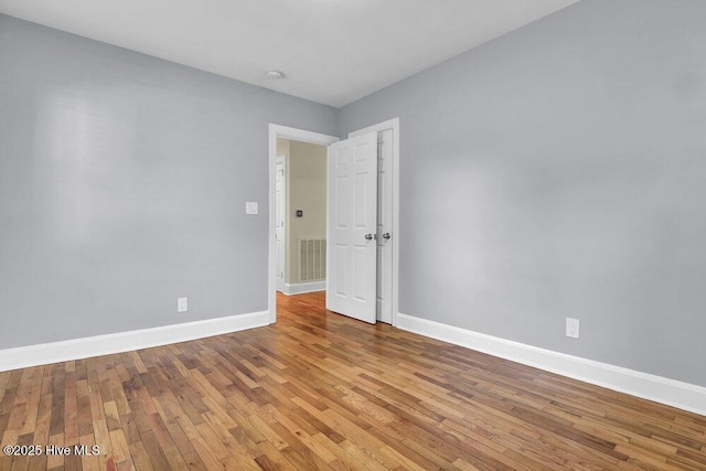 empty room with baseboards and wood finished floors
