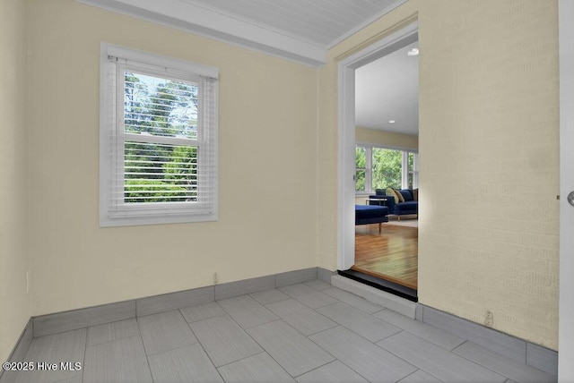 spare room featuring baseboards and crown molding