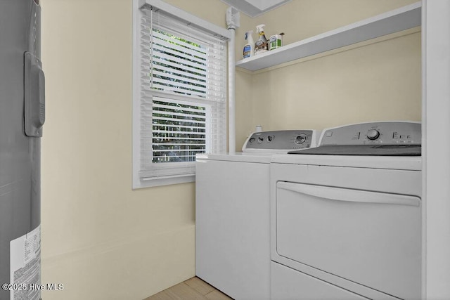 laundry area featuring independent washer and dryer, plenty of natural light, and light wood finished floors