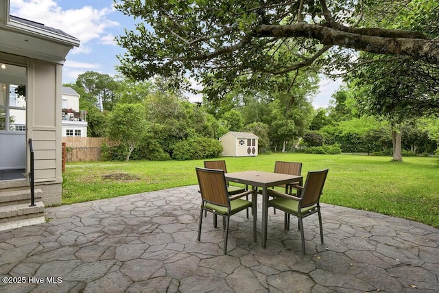 view of patio with a storage shed, outdoor dining area, and an outbuilding