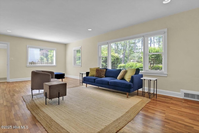 living area with hardwood / wood-style floors, baseboards, and recessed lighting