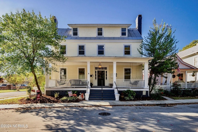 view of front of home with covered porch and a chimney