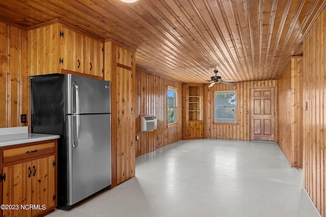 kitchen with stainless steel fridge, wood walls, ceiling fan, and wood ceiling