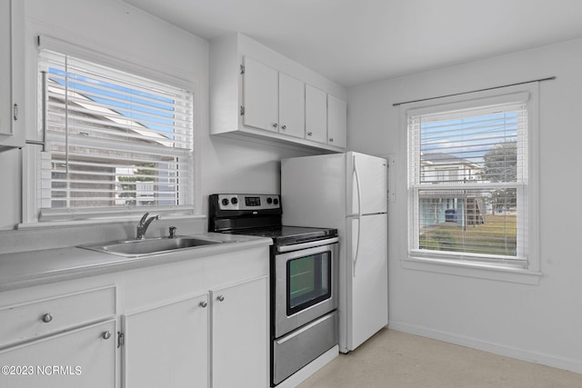 kitchen featuring white cabinetry, electric range, sink, and fridge