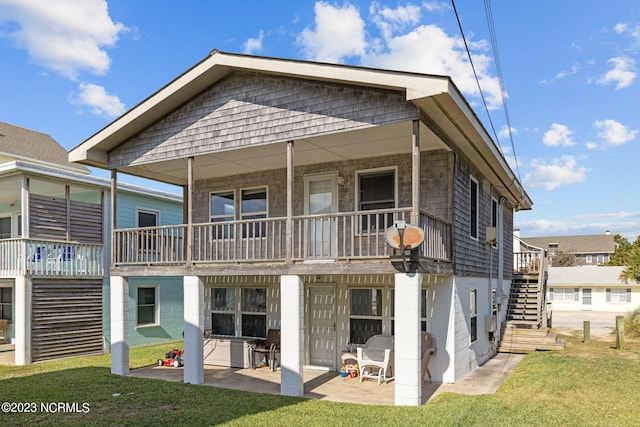 rear view of house featuring a balcony, a yard, and a patio area