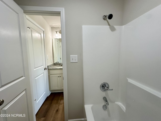 bathroom featuring hardwood / wood-style floors, vanity, and shower / bathtub combination