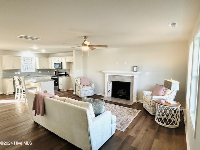 living room featuring ceiling fan and dark hardwood / wood-style flooring