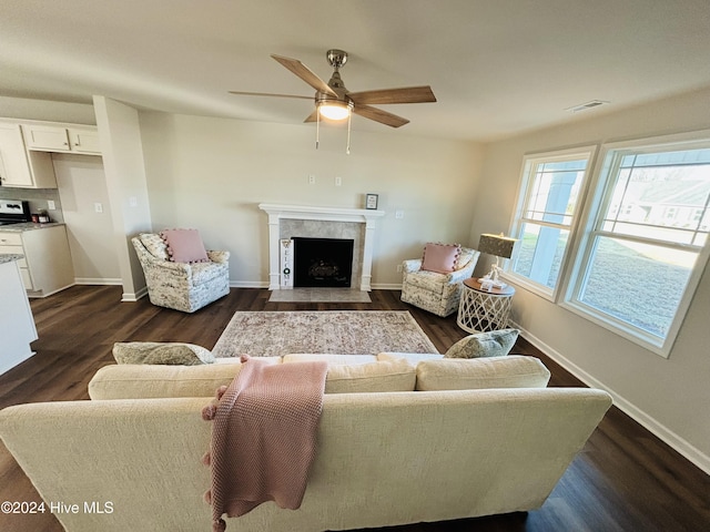 living room featuring dark hardwood / wood-style floors, ceiling fan, and a high end fireplace