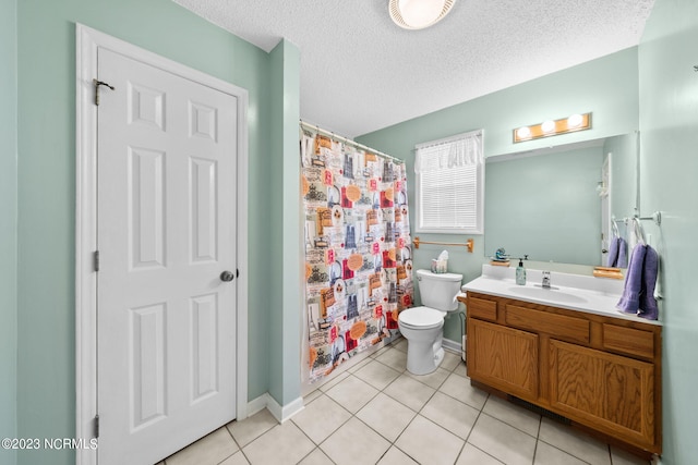 bathroom featuring a textured ceiling, tile flooring, toilet, and large vanity