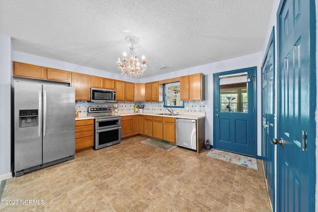 kitchen with an inviting chandelier, decorative light fixtures, light tile floors, and stainless steel appliances