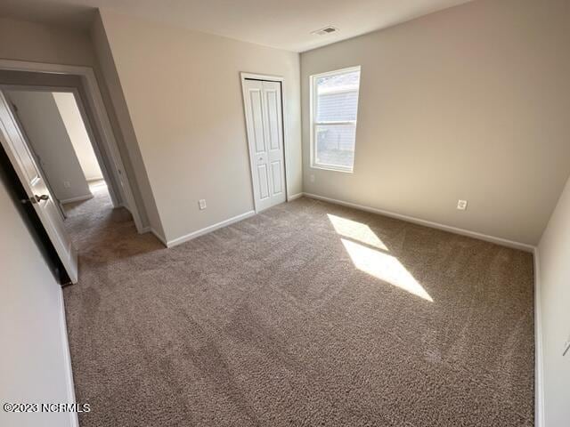 unfurnished bedroom featuring dark colored carpet and a closet