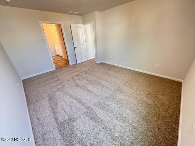 unfurnished bedroom featuring connected bathroom and light hardwood / wood-style floors