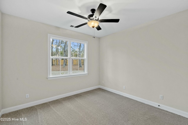 carpeted spare room with ceiling fan, visible vents, and baseboards