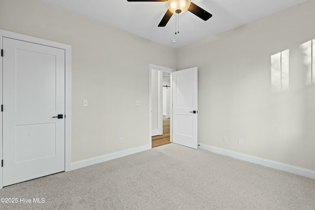 unfurnished bedroom featuring carpet, a ceiling fan, and baseboards