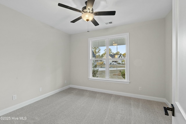 carpeted empty room featuring visible vents, baseboards, and a ceiling fan