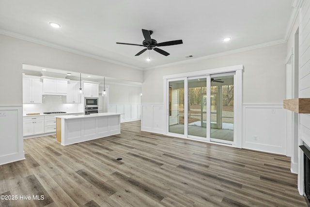 unfurnished living room featuring crown molding and wood finished floors