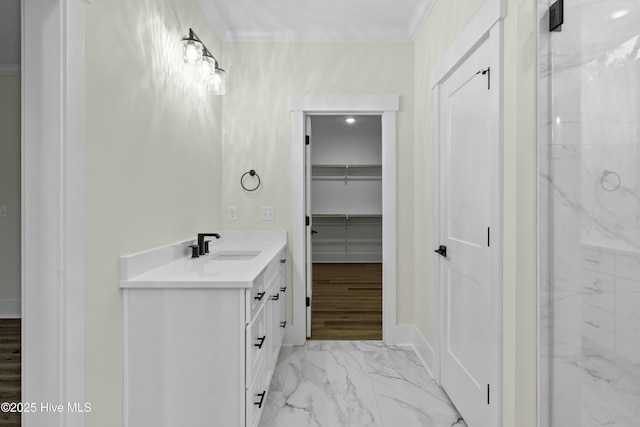 full bathroom featuring vanity, marble finish floor, ornamental molding, a spacious closet, and walk in shower