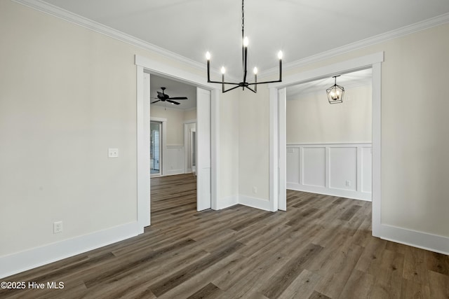 unfurnished dining area featuring ornamental molding, a decorative wall, and dark wood-type flooring