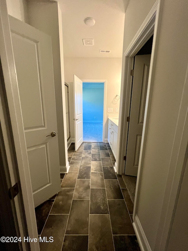 corridor featuring dark tile patterned floors