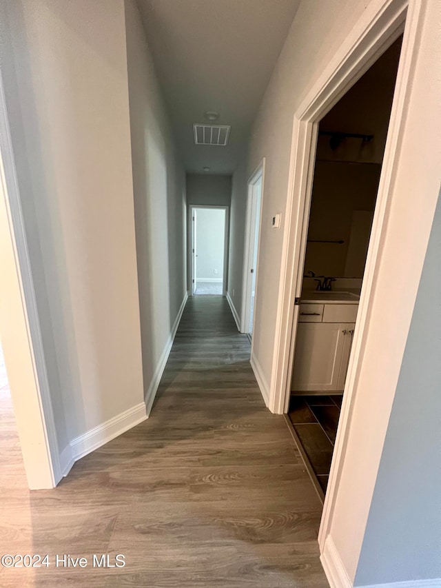 hallway featuring hardwood / wood-style floors and sink