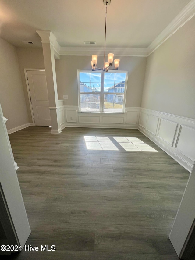 unfurnished dining area with an inviting chandelier, light hardwood / wood-style flooring, and decorative columns