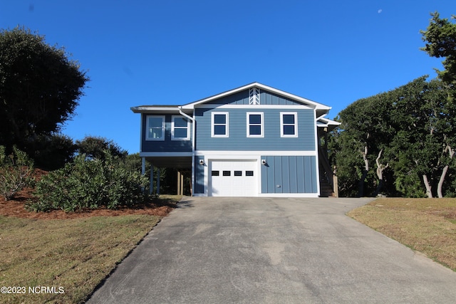 front of property with a garage, a front yard, and a carport