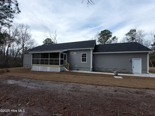 view of front facade featuring roof with shingles, crawl space, and a sunroom