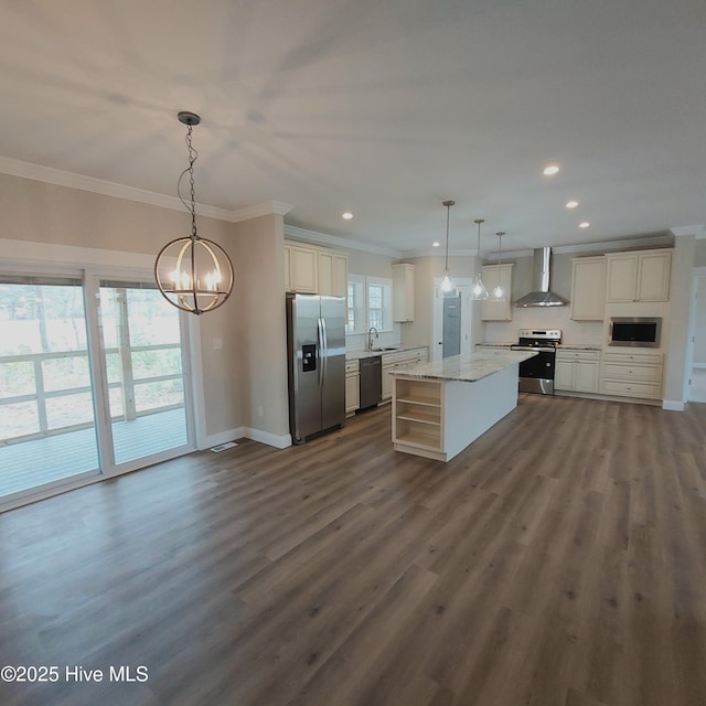 kitchen featuring dark wood-type flooring, a sink, appliances with stainless steel finishes, wall chimney range hood, and ornamental molding