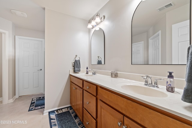 bathroom featuring tile patterned flooring and dual bowl vanity