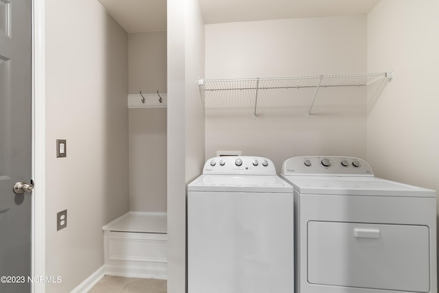 washroom with washing machine and clothes dryer and light tile patterned floors