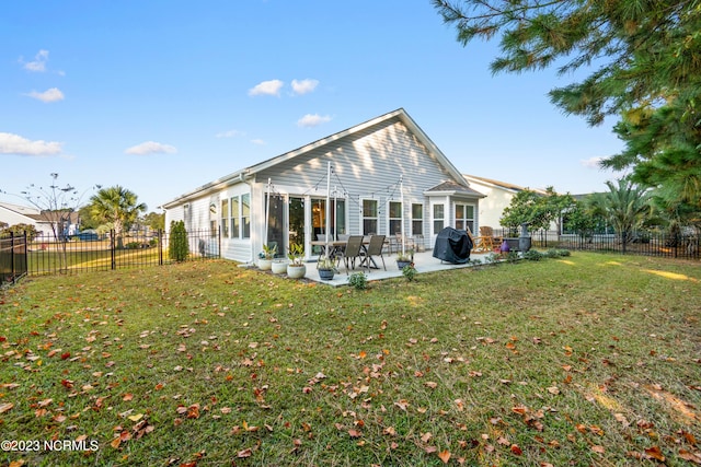 back of property with a yard and a patio area