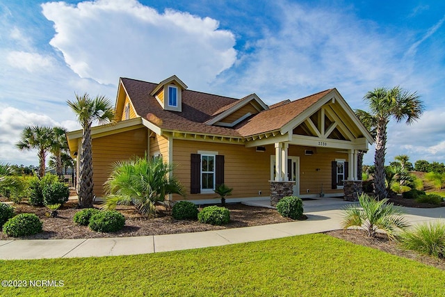 craftsman inspired home with a porch and a front yard