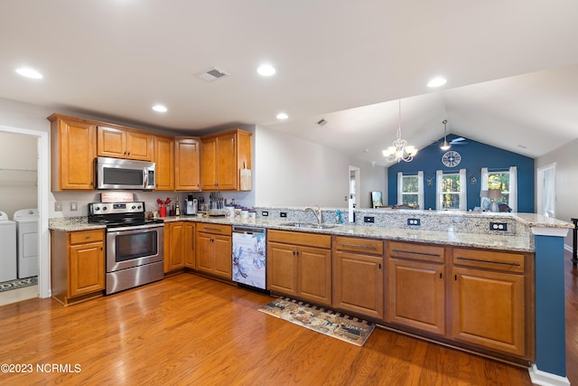 kitchen featuring decorative light fixtures, appliances with stainless steel finishes, light wood-type flooring, and kitchen peninsula