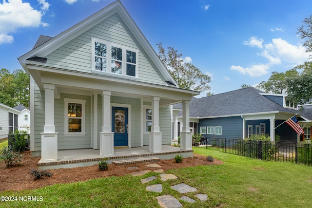 bungalow-style home featuring a front lawn and covered porch