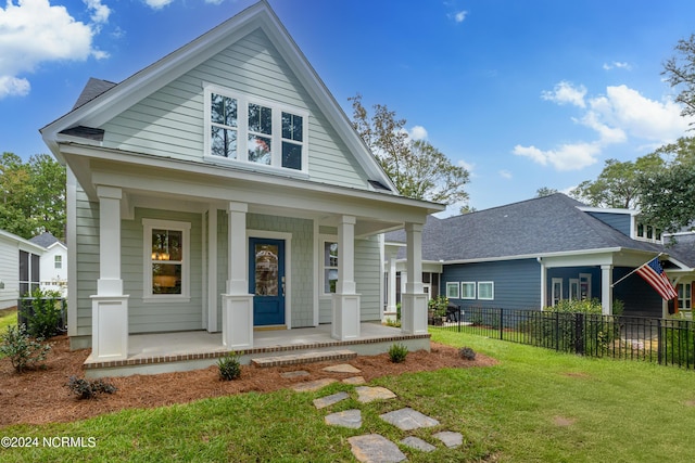 view of front of property featuring covered porch and a front yard