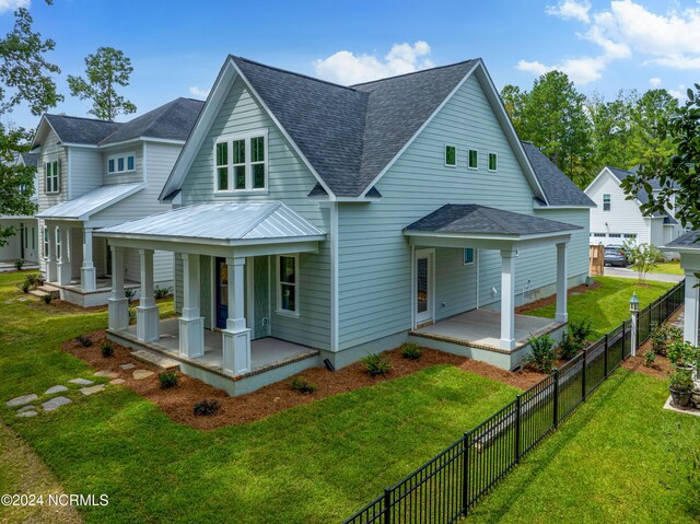 rear view of house featuring a yard and covered porch