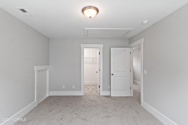 unfurnished bedroom featuring a walk in closet, a closet, and carpet flooring