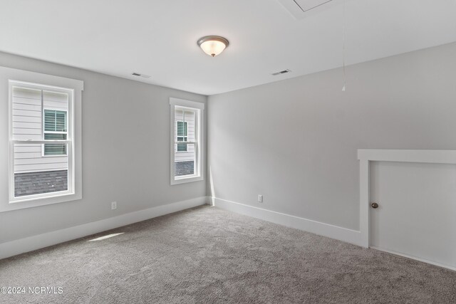 carpeted empty room with lofted ceiling