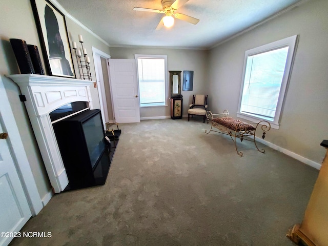 sitting room featuring ornamental molding, carpet flooring, a ceiling fan, and baseboards