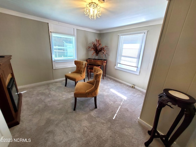 sitting room with ornamental molding, plenty of natural light, carpet flooring, and a notable chandelier